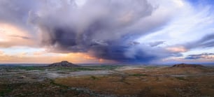 a large cloud is in the sky over a desert