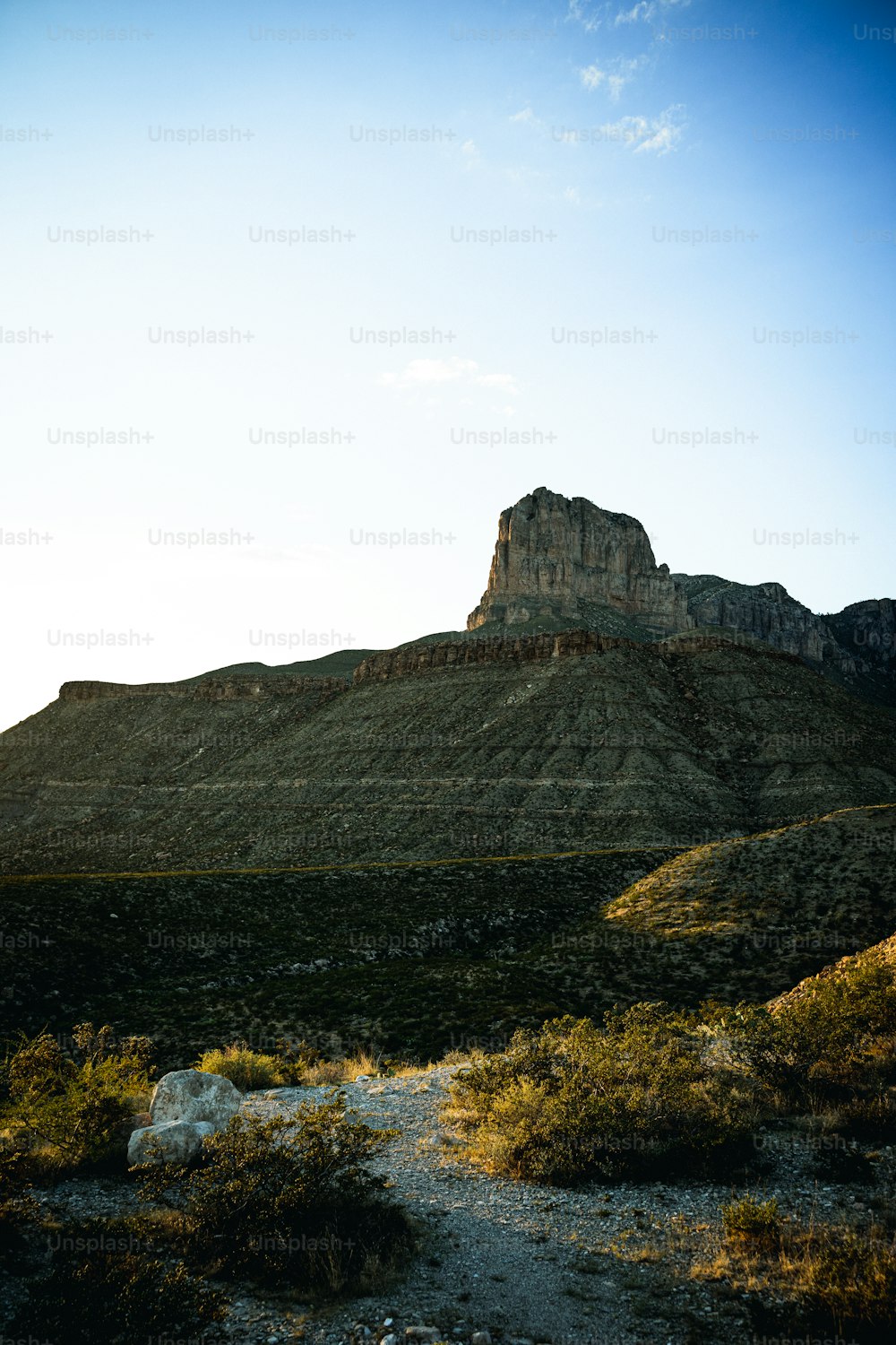 Una gran montaña con una roca muy alta en la cima
