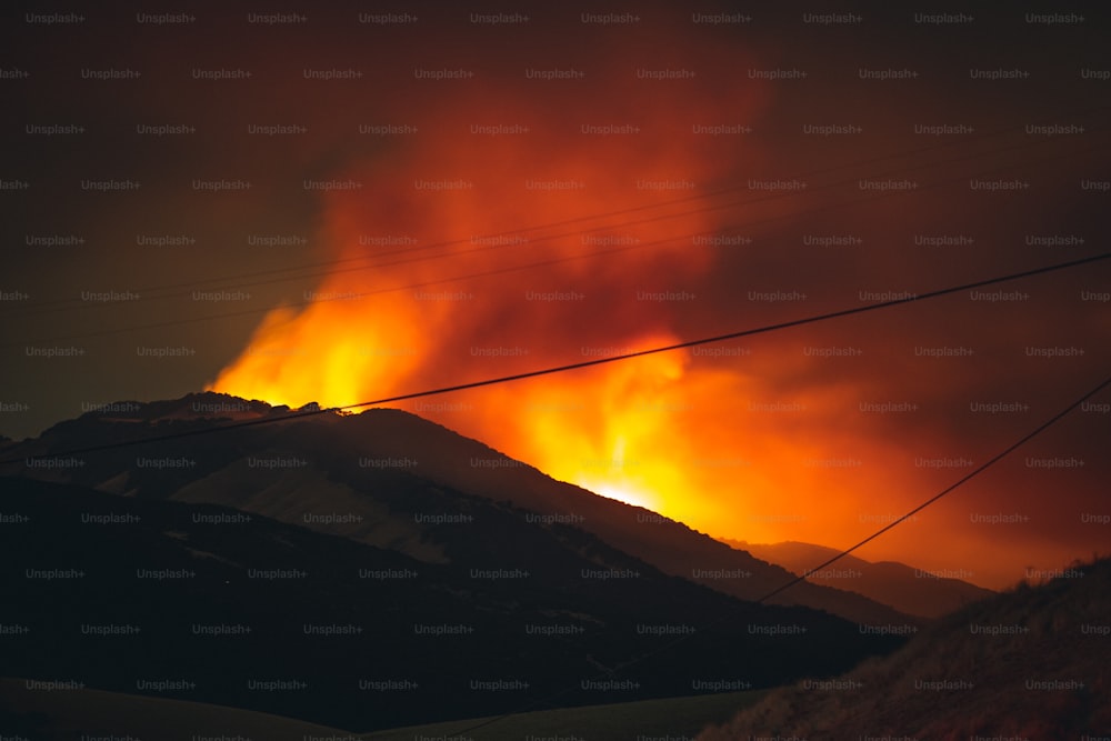 um incêndio ardendo no céu sobre uma montanha