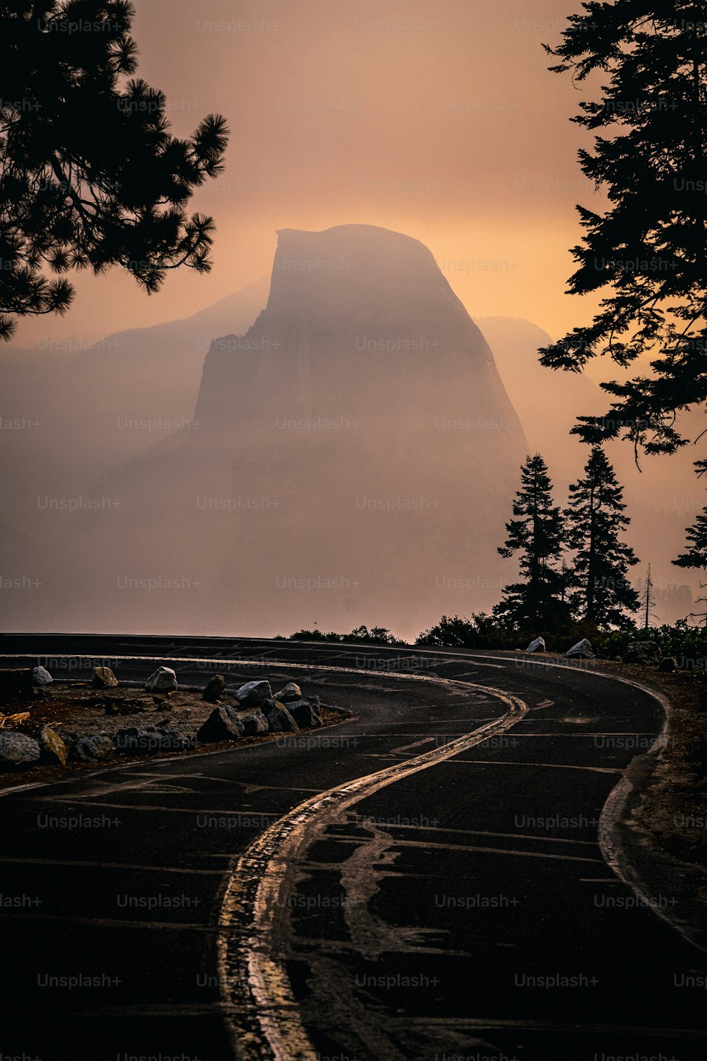 a winding road with a mountain in the background