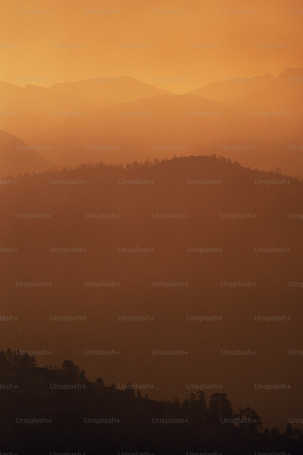 a hazy view of a mountain range with trees