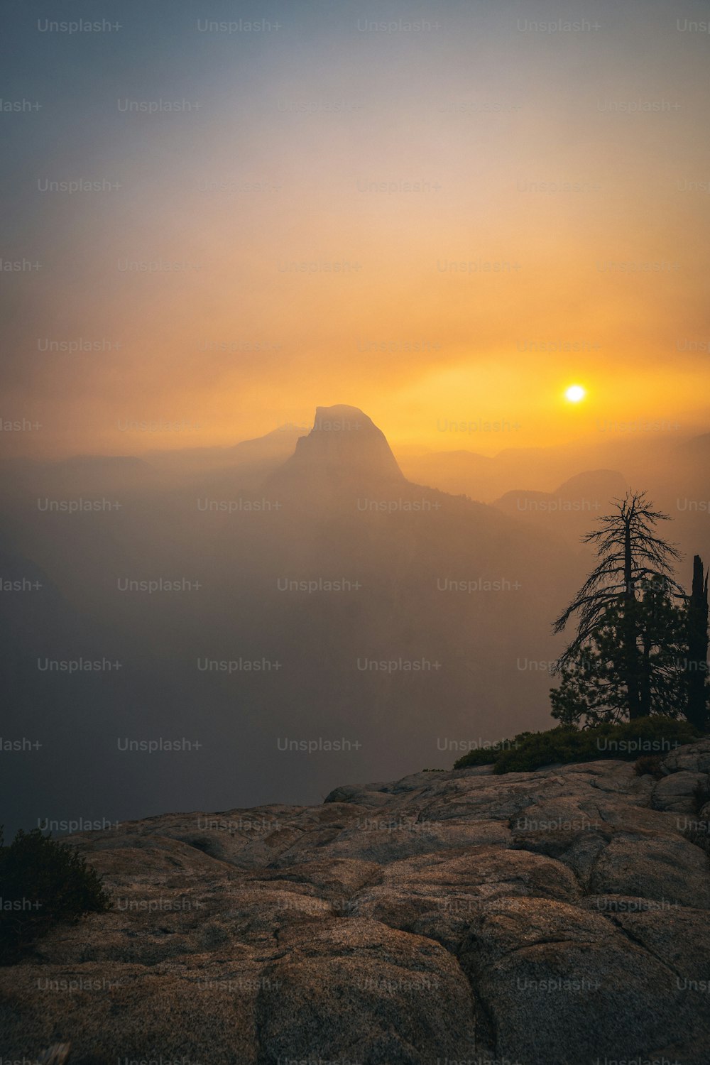 Le soleil se couche sur une montagne brumeuse