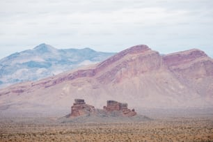 a mountain range in the distance with a few rocks in the foreground