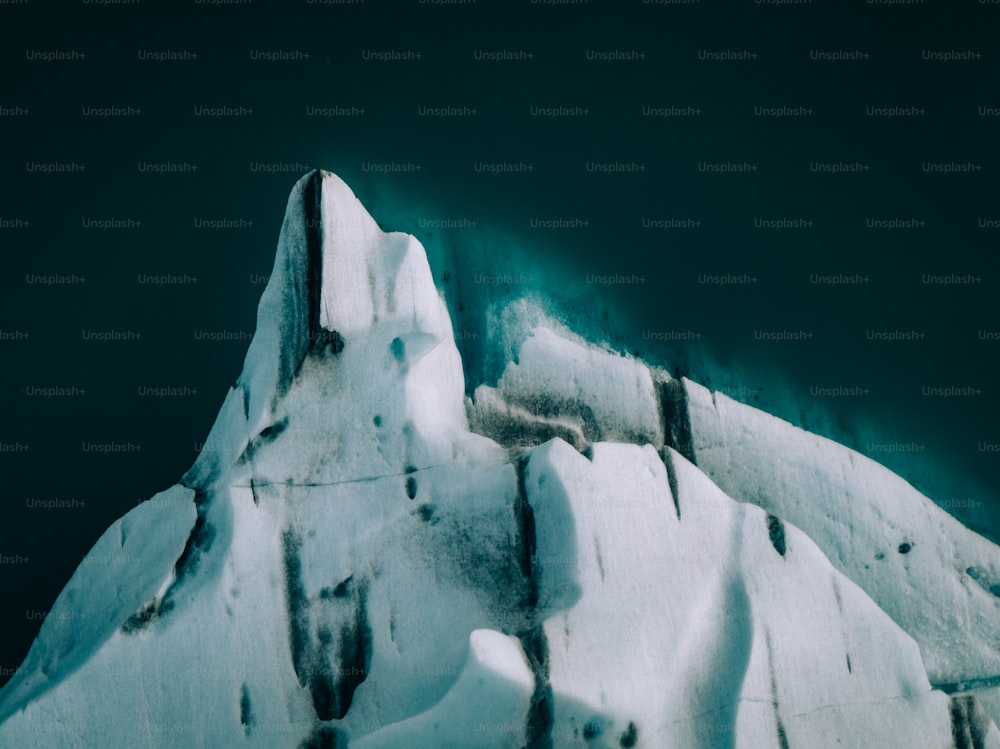 a large iceberg with snow on the side of it