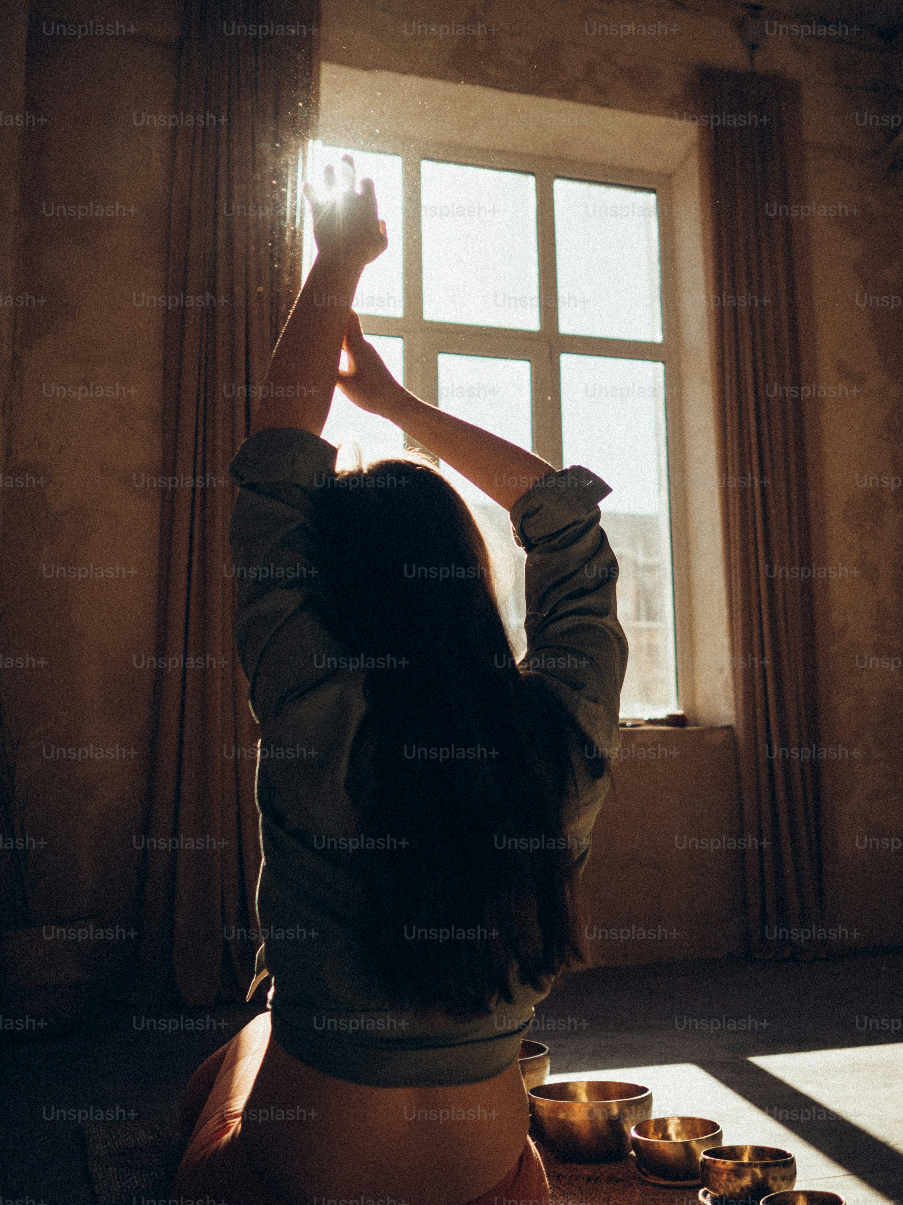 a woman sitting on the floor in front of a window