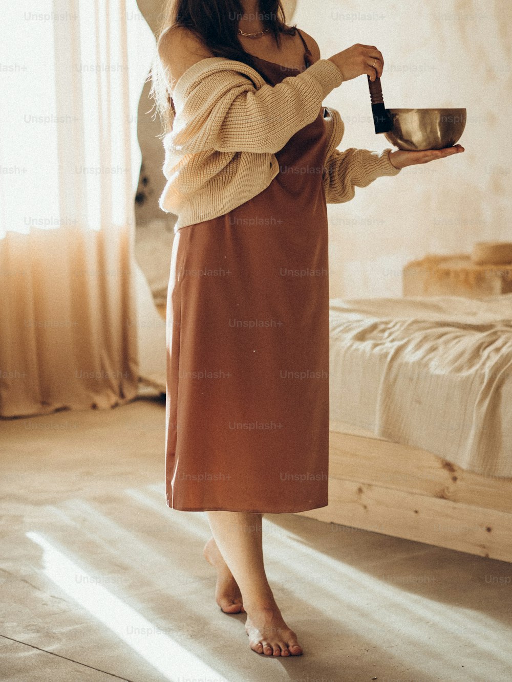 a woman in a brown dress is holding a bowl