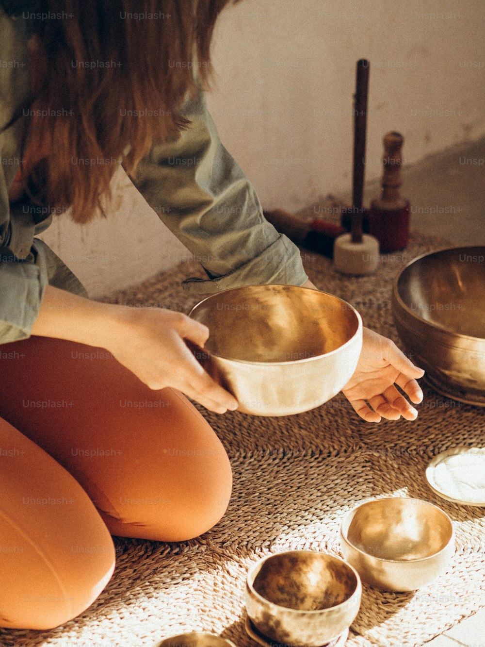 a woman sitting on the floor holding a bowl