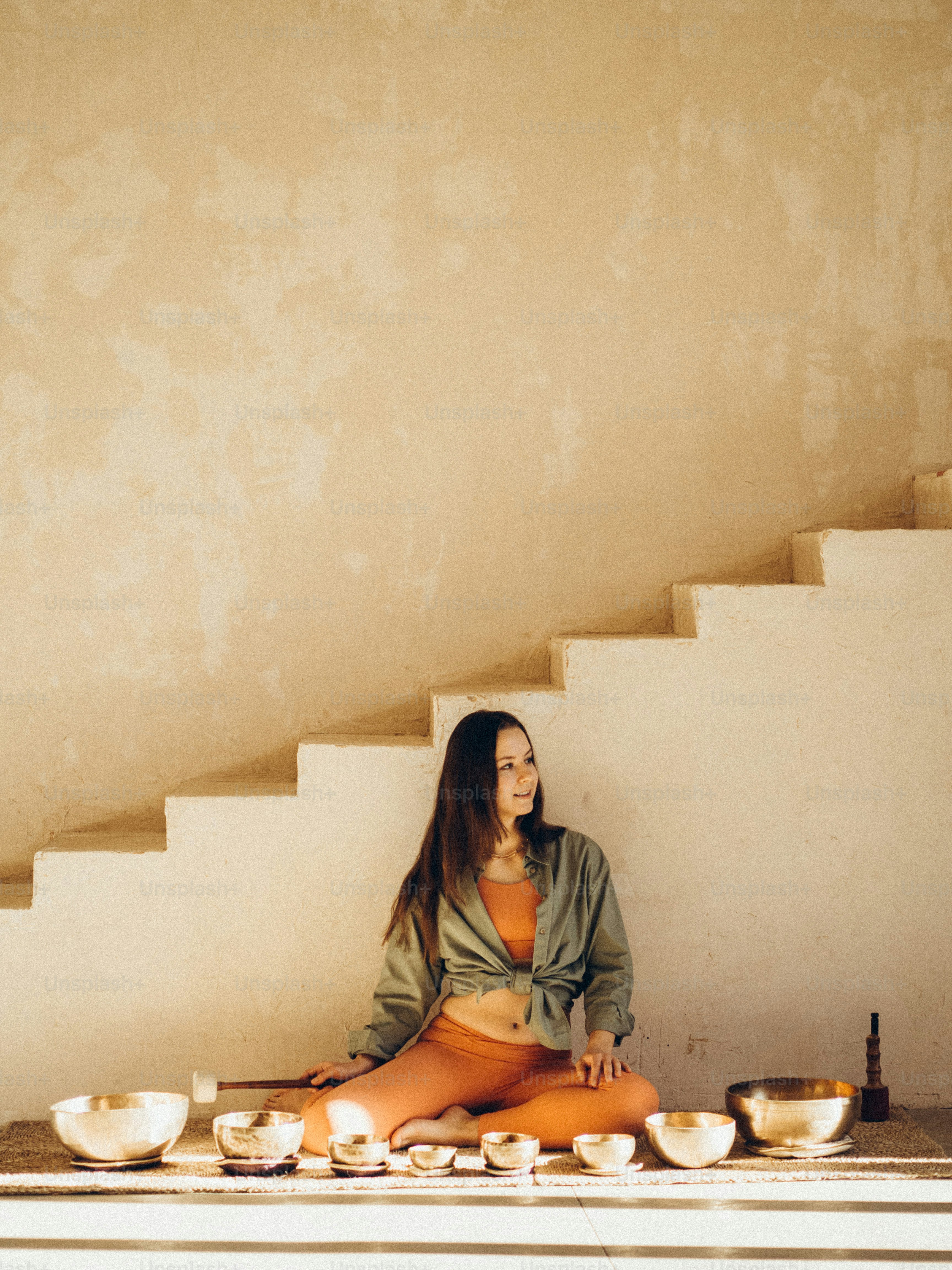 eine frau, die auf dem boden vor einigen schüsseln sitzt
