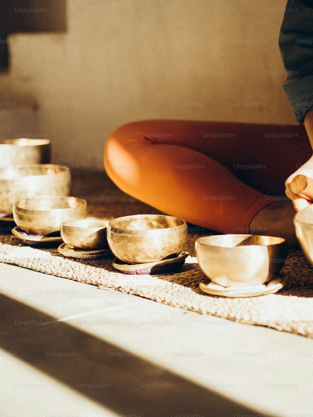 a woman is sitting on the floor with her bowls