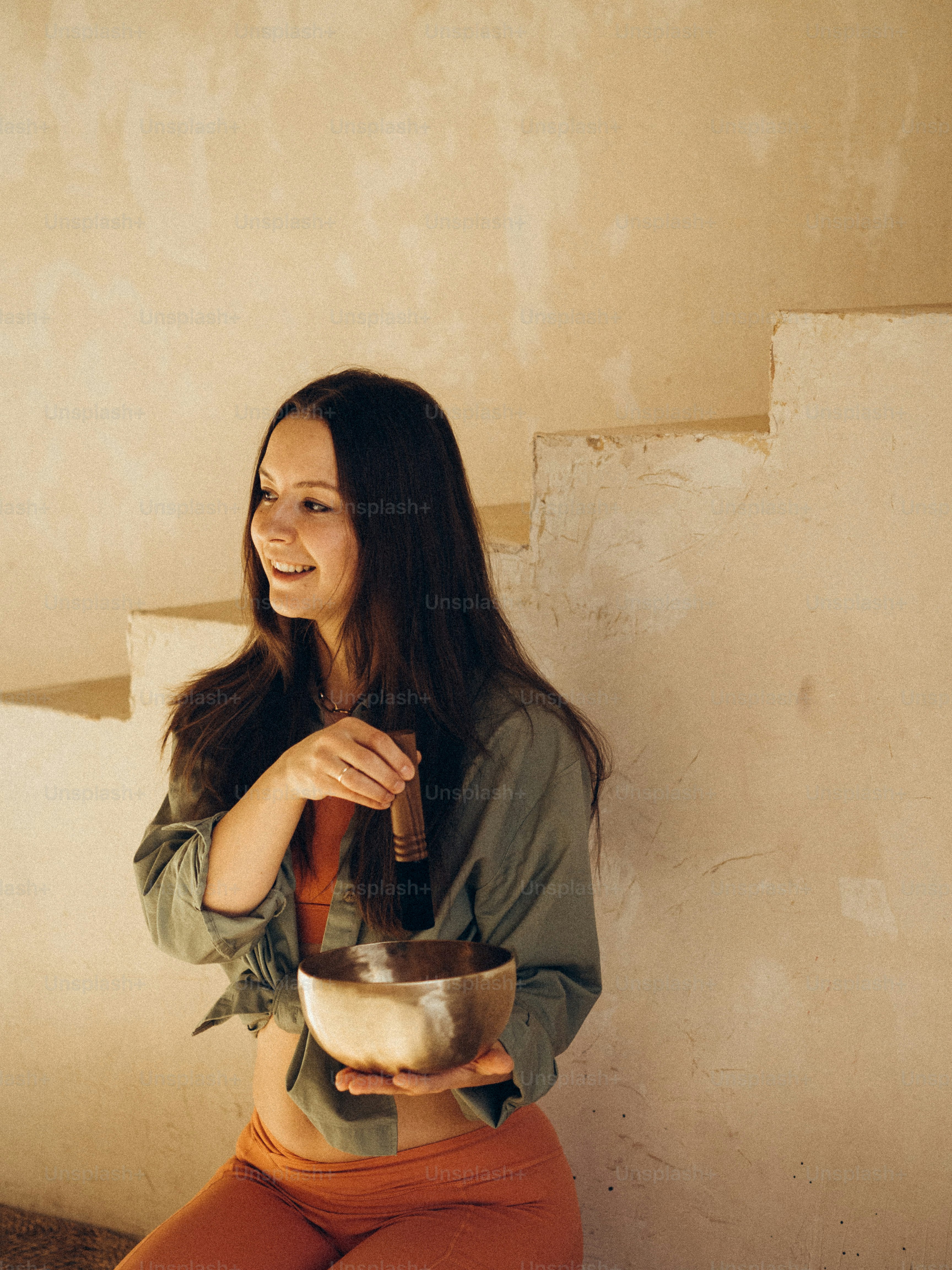 eine frau, die auf dem boden sitzt und eine schüssel hält