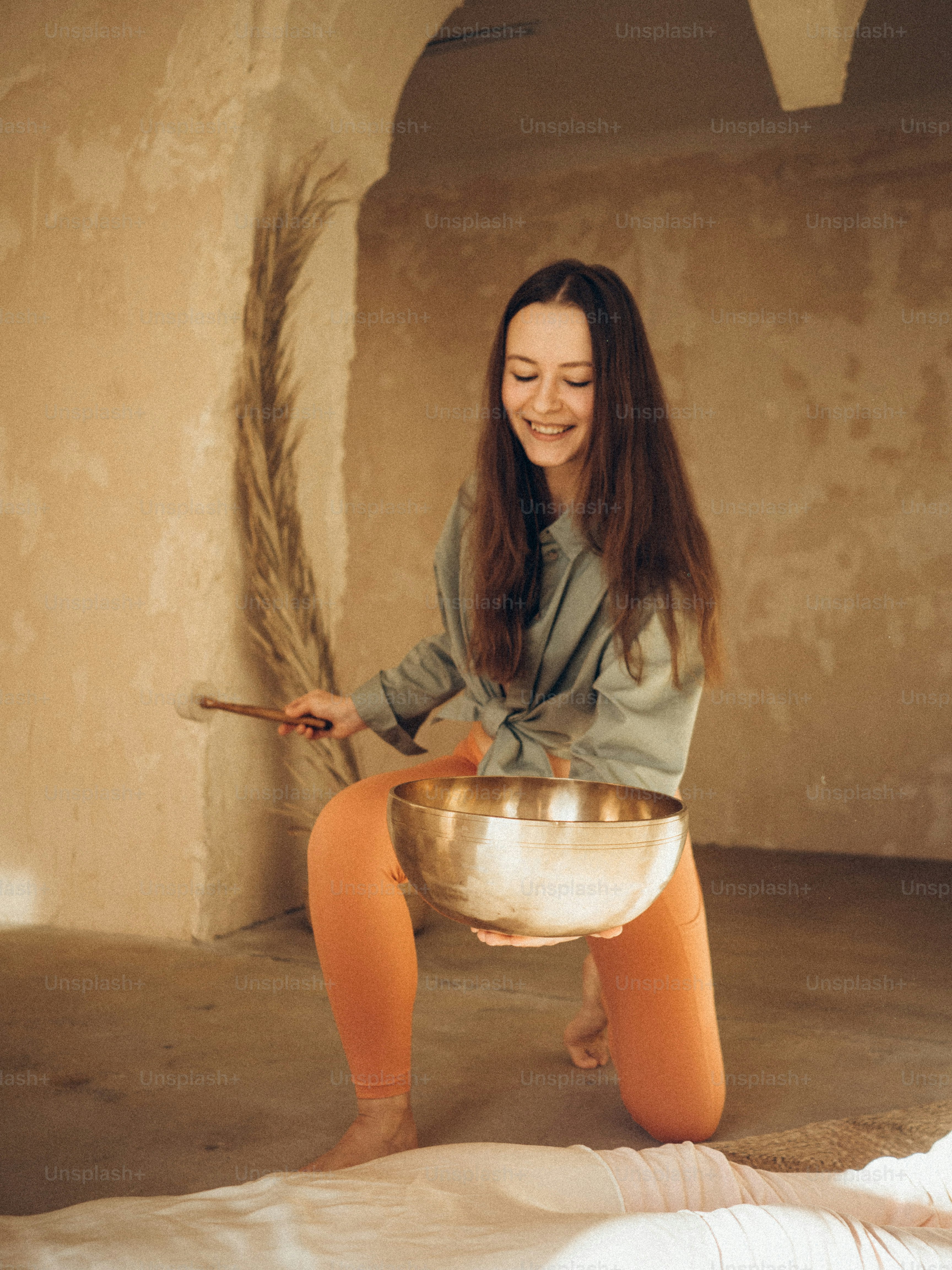a woman sitting on the floor holding a bowl
