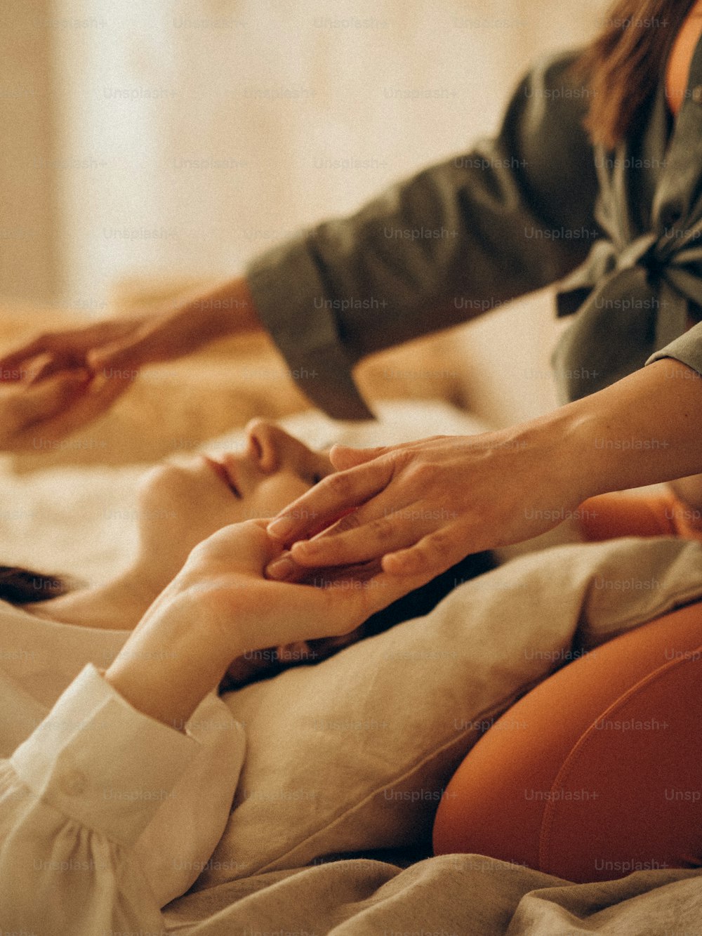 a woman receiving a massage from a woman in a bed