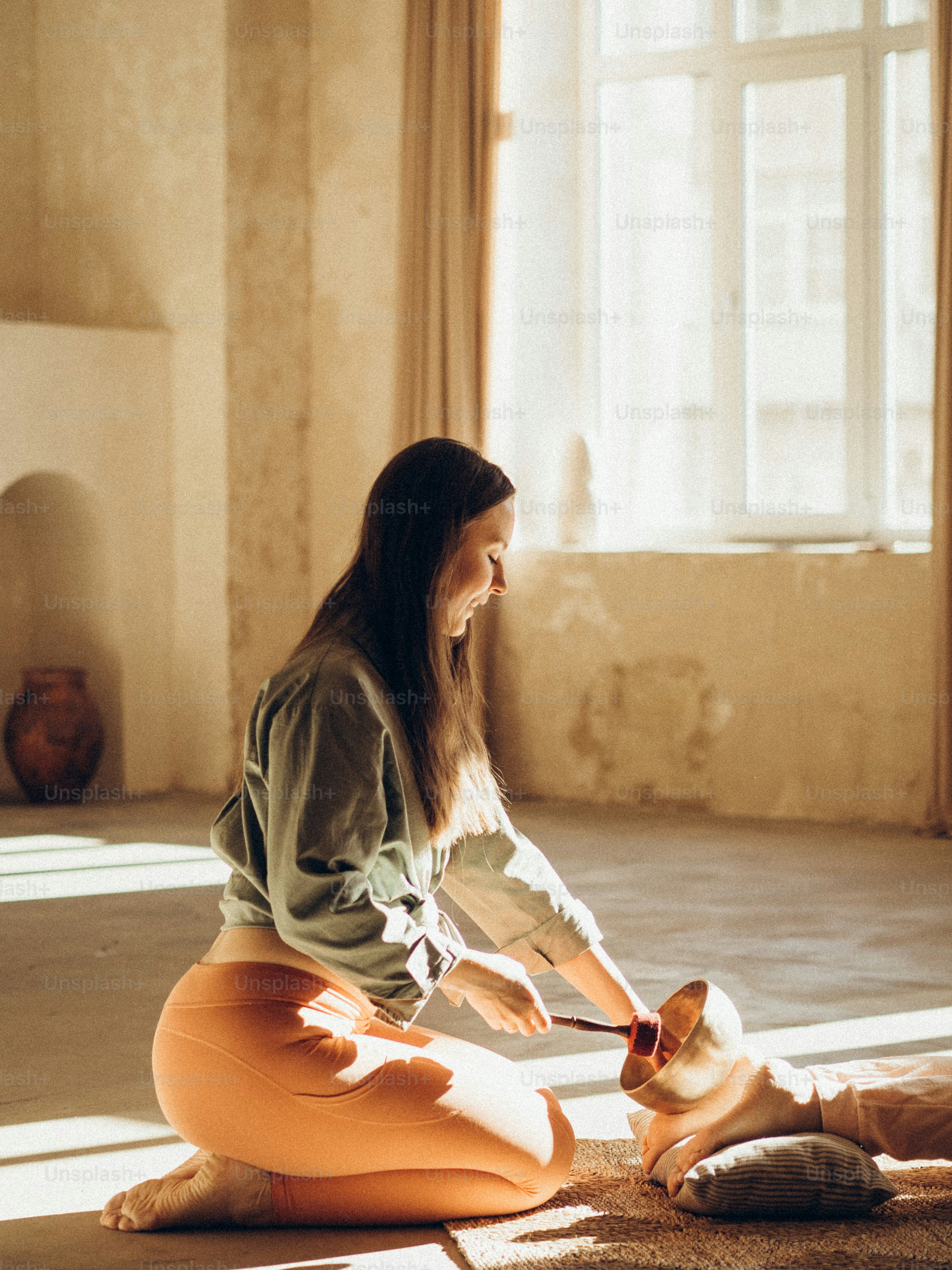 a woman sitting on the floor petting a dog
