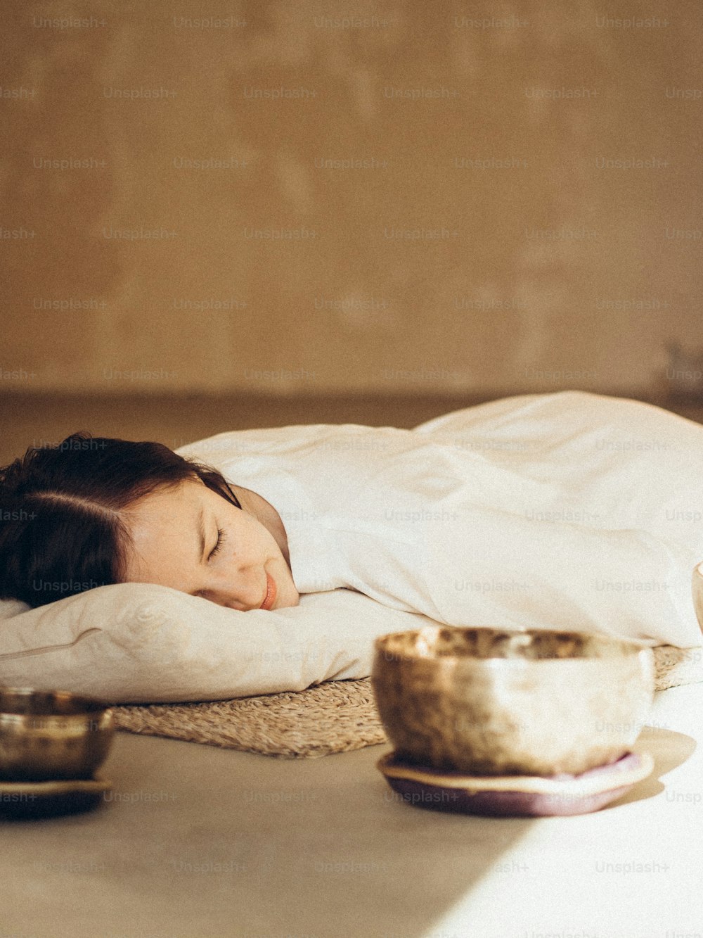 uma mulher está dormindo em uma cama com um cobertor branco