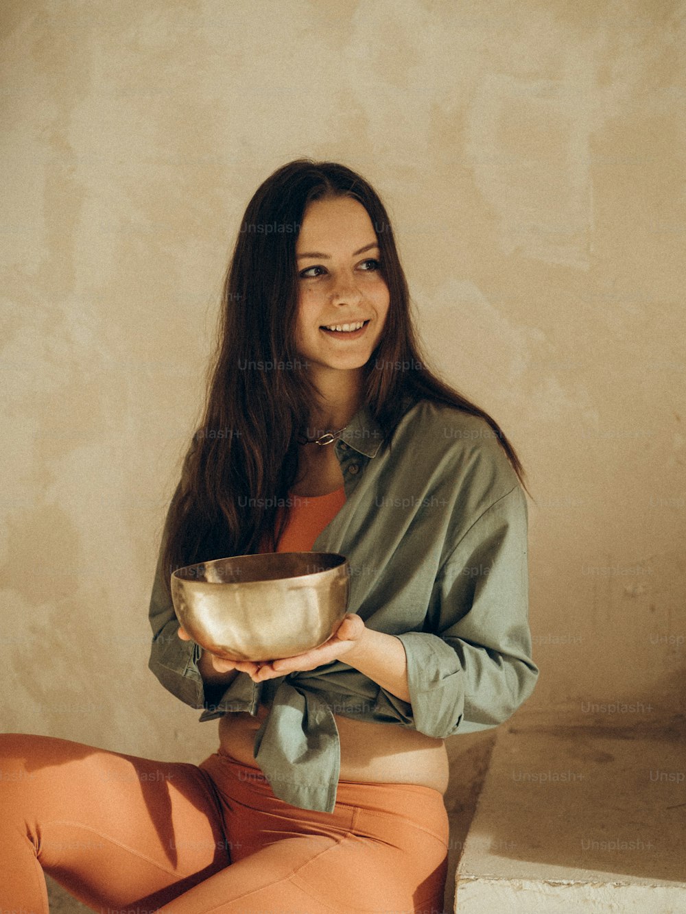 a woman sitting on a step holding a bowl