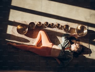 a woman laying on the ground next to a bunch of bowls