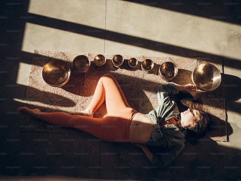 a woman laying on the ground next to a bunch of bowls