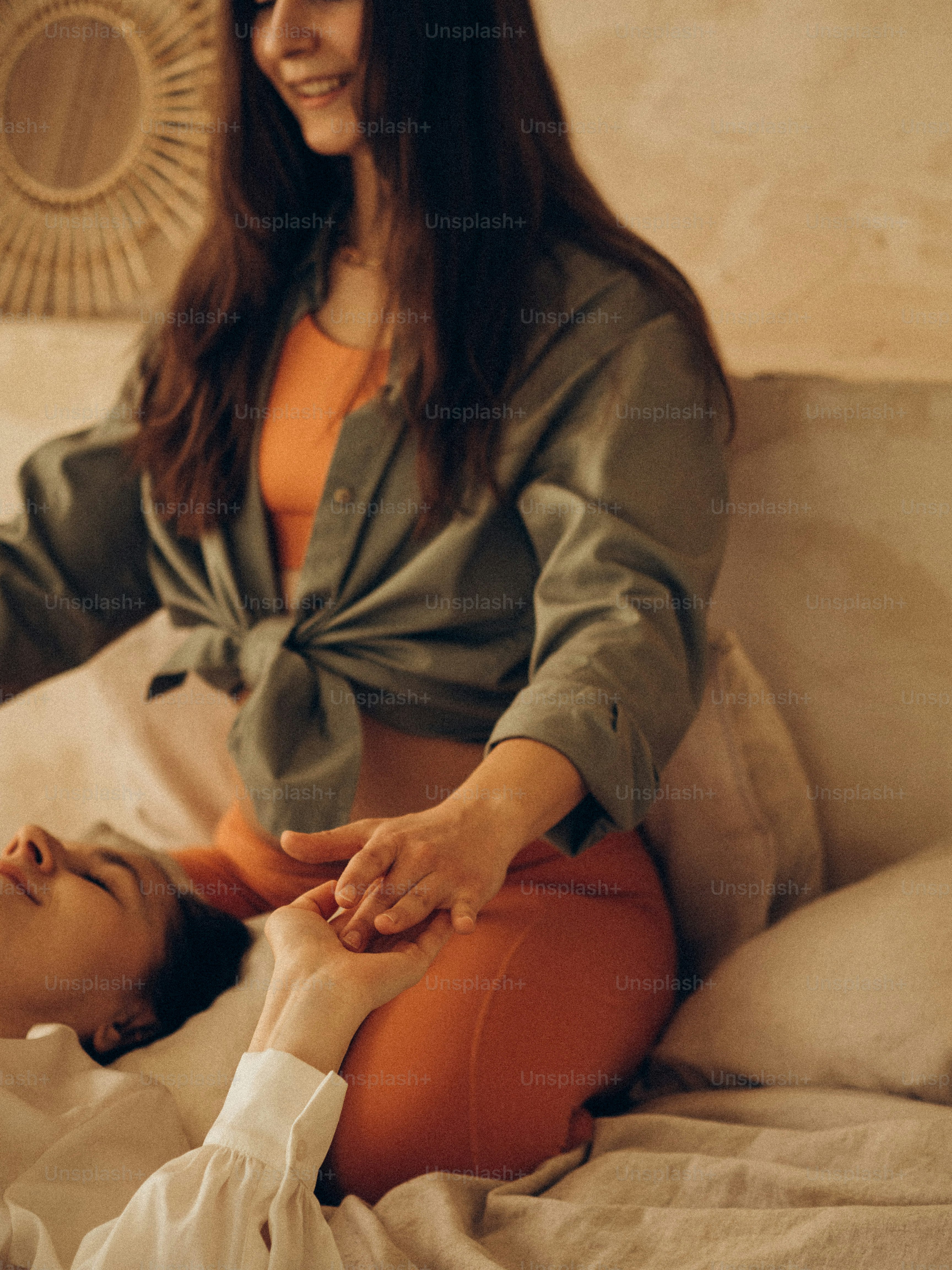 una donna seduta sopra un letto accanto ad un'altra donna