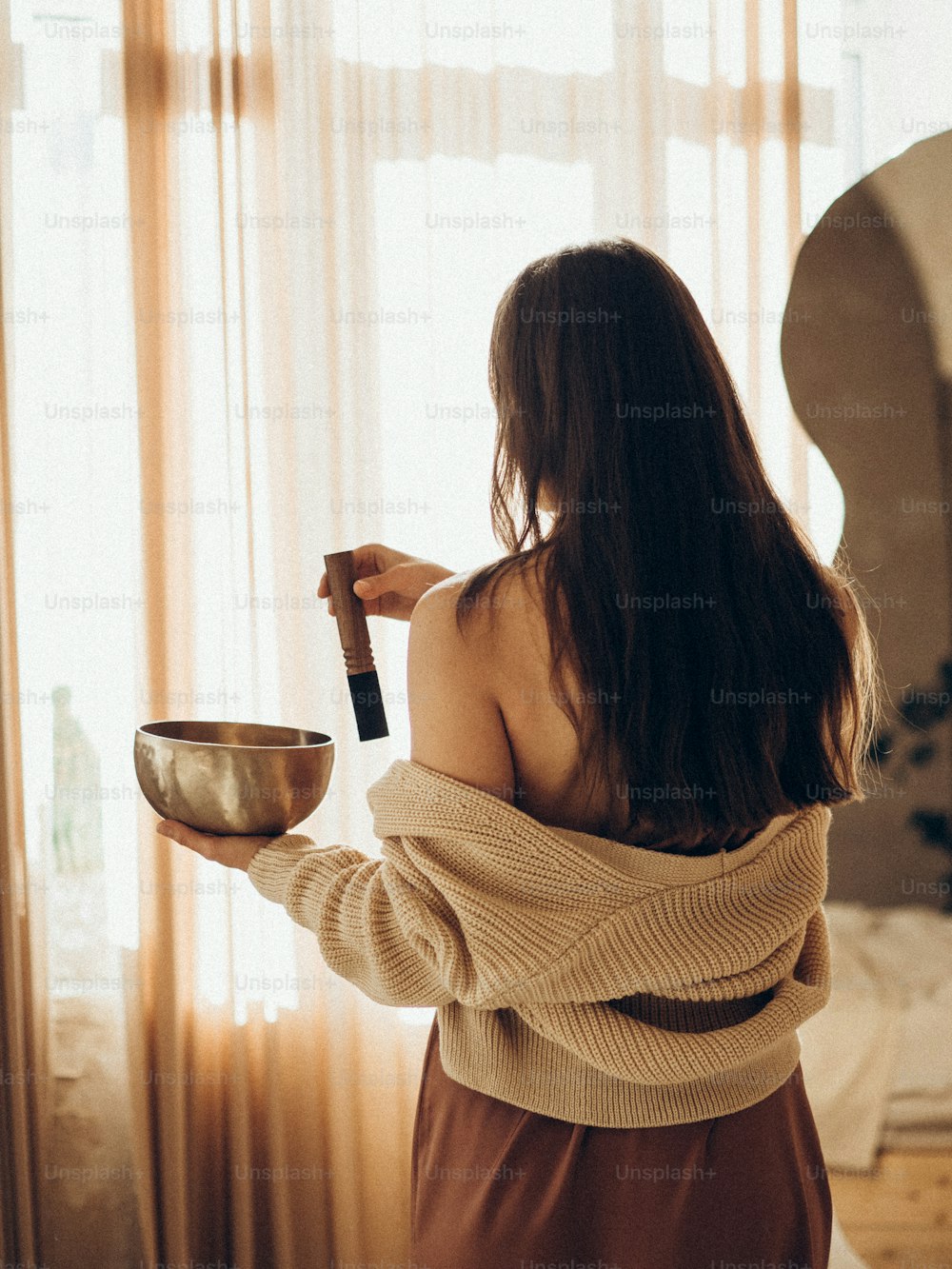 a woman holding a bowl and a bottle of wine