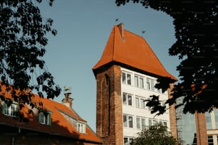 um edifício alto com um telhado vermelho e uma torre do relógio