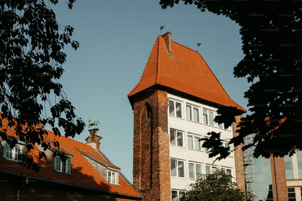 Un edificio alto con un techo rojo y una torre del reloj