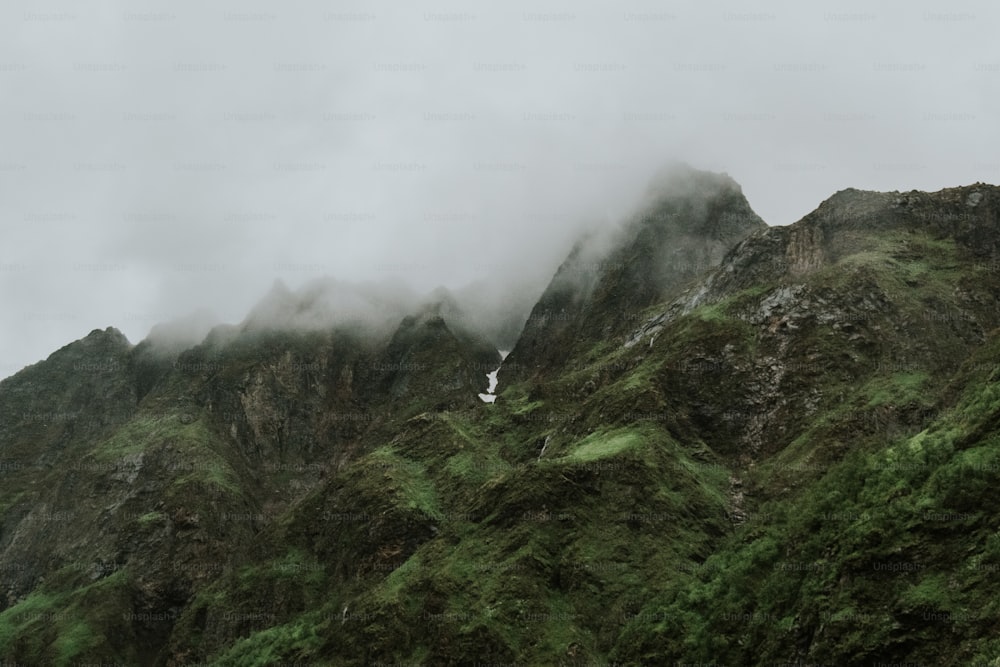 a very tall mountain covered in green grass