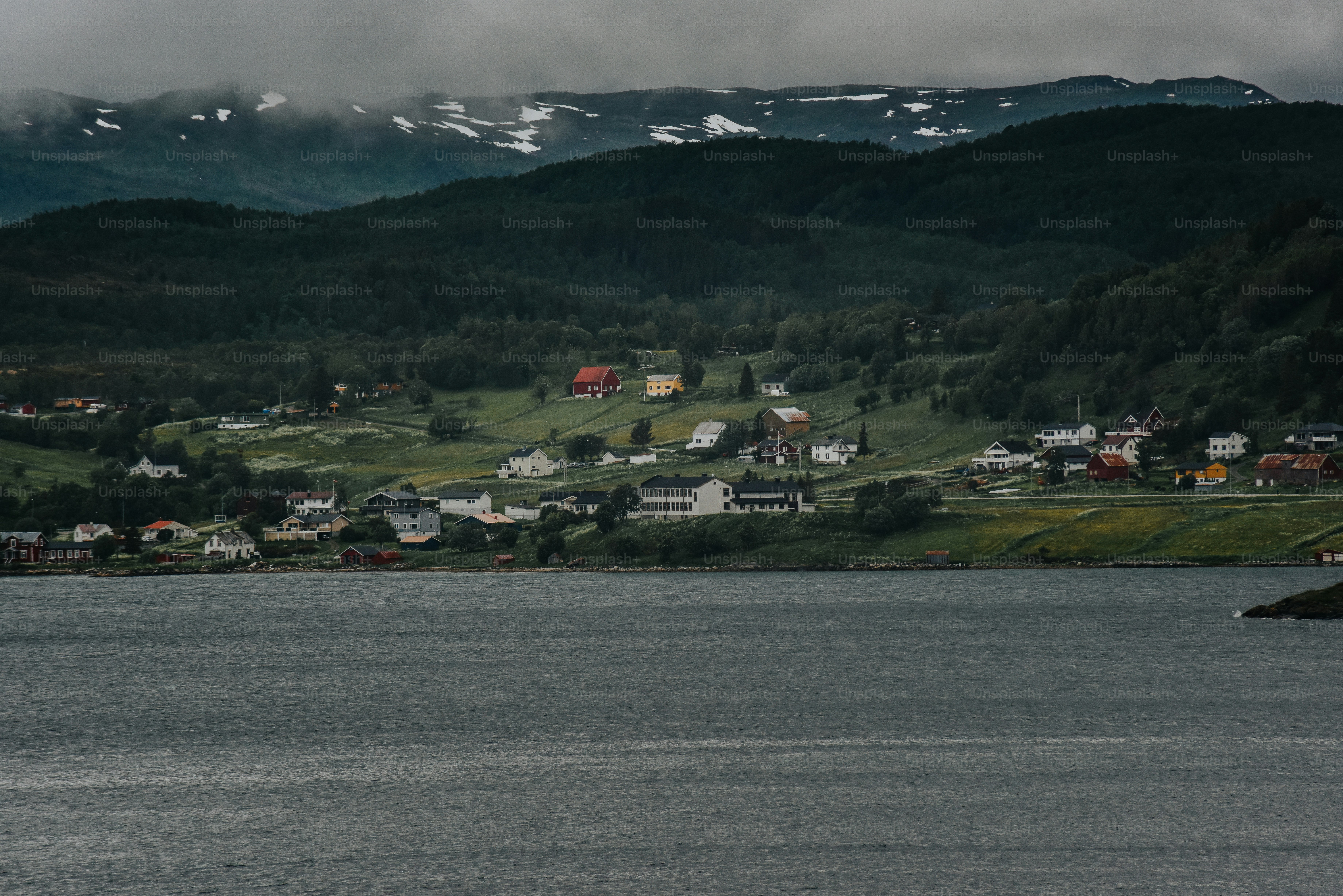 a body of water with houses on a hill in the background