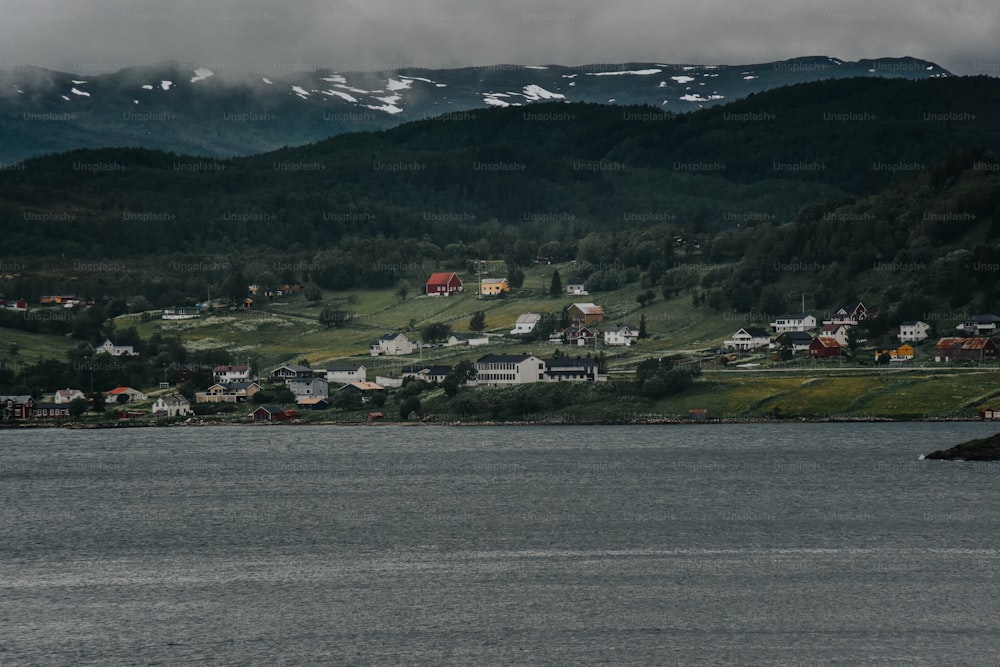 a body of water with houses on a hill in the background