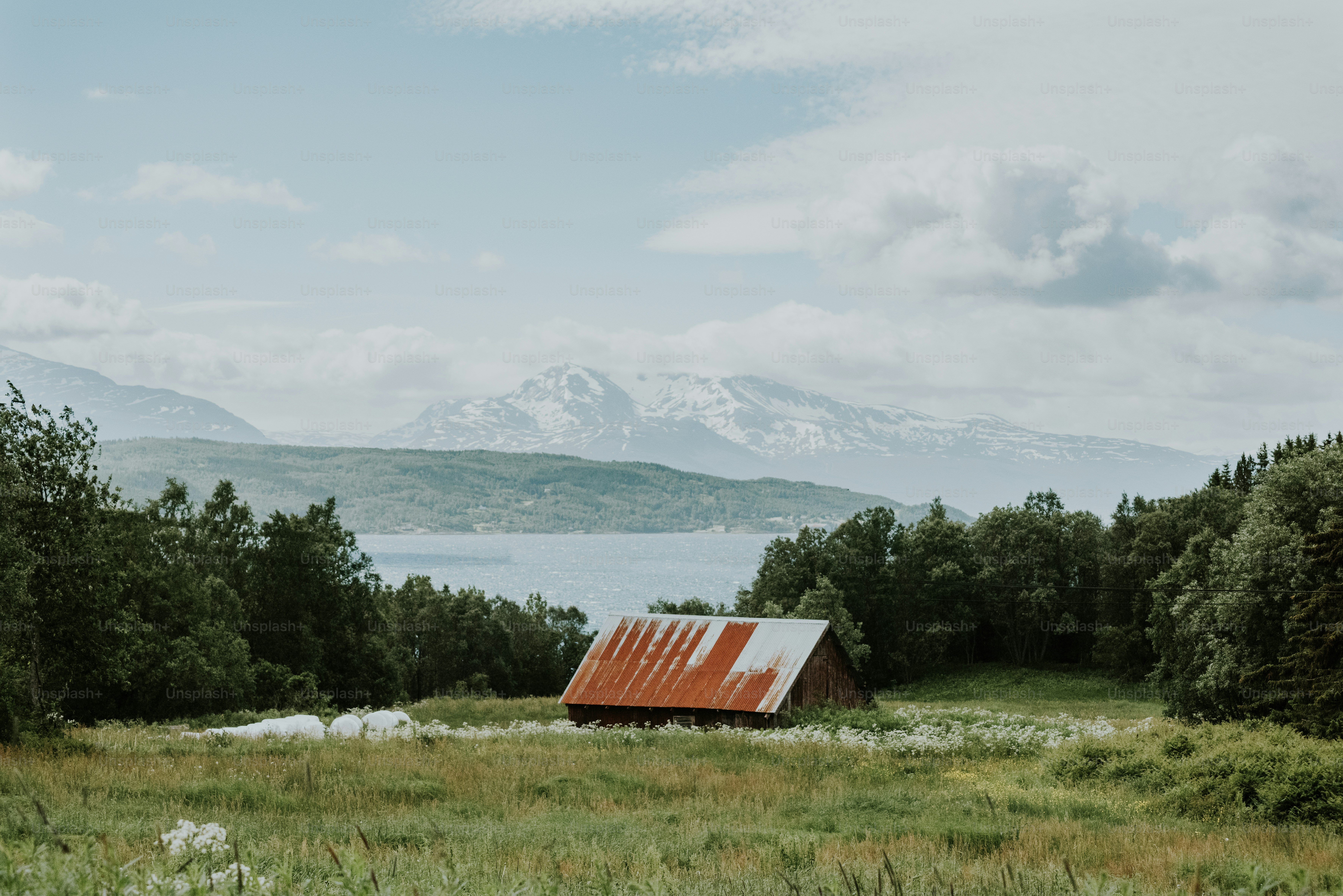 a barn in a field with mountains in the background