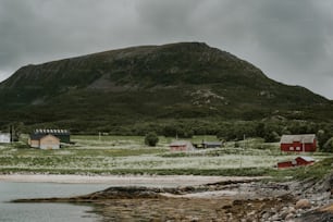 a mountain with a house on it and a body of water in front of it