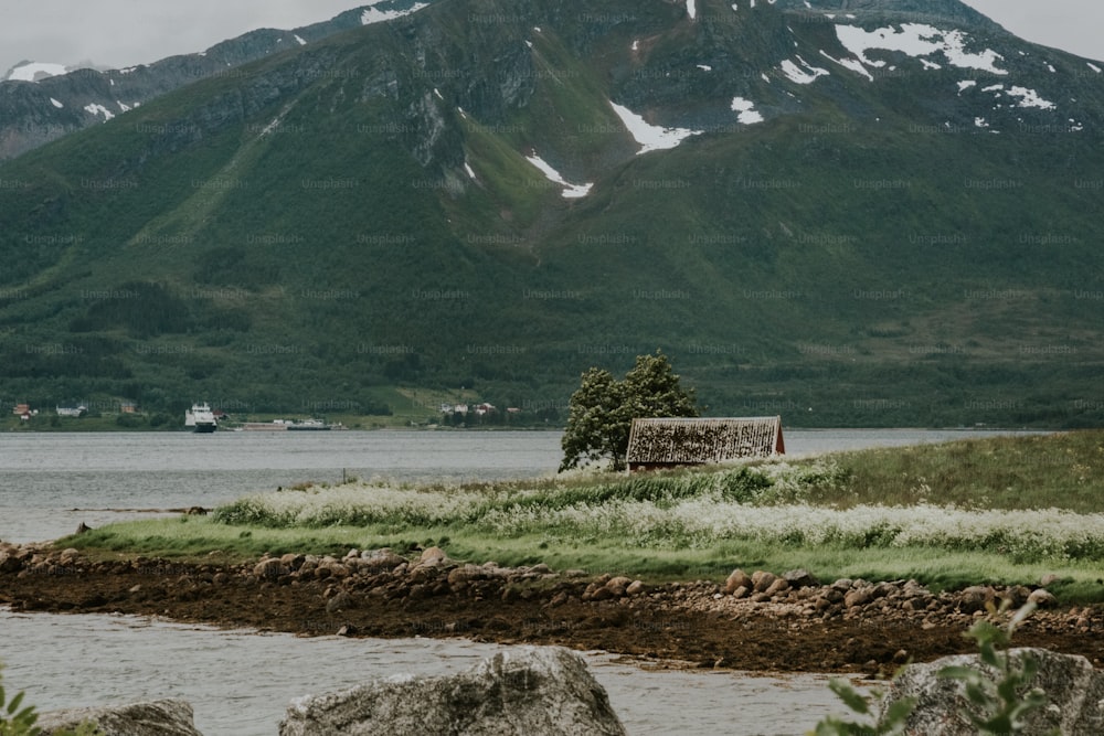 a small hut sitting on a small island in the middle of a lake