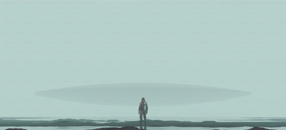 Un uomo in piedi sulla cima di una spiaggia vicino all'oceano