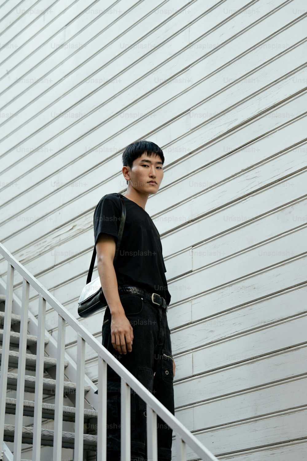 Ein junger Mann, der auf den Stufen eines Gebäudes steht