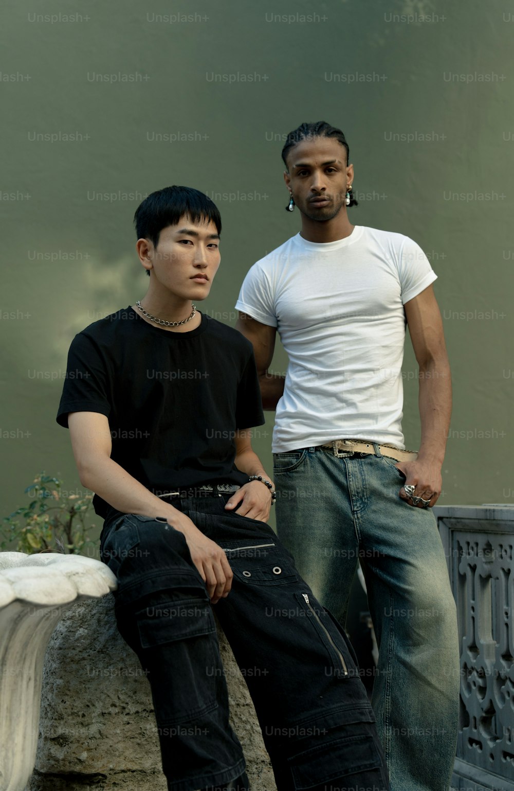 Deux jeunes hommes sont assis sur un rebord