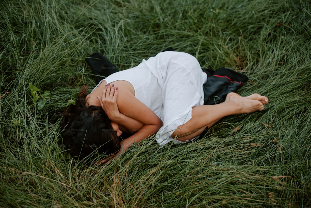 Una donna che giace in un campo di erba alta