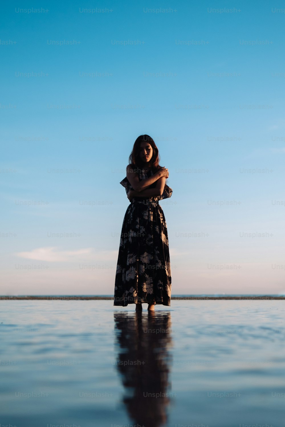 a woman standing in the middle of a body of water