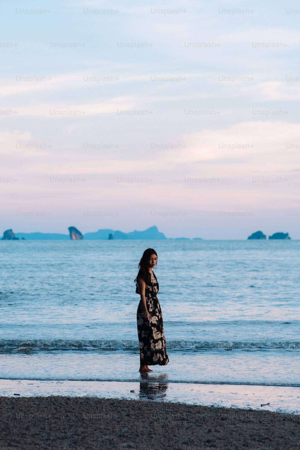 海の隣のビーチに立つ女性