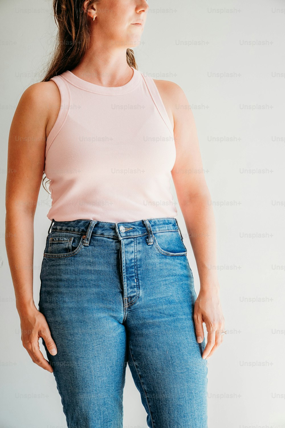 a woman in a pink tank top and jeans