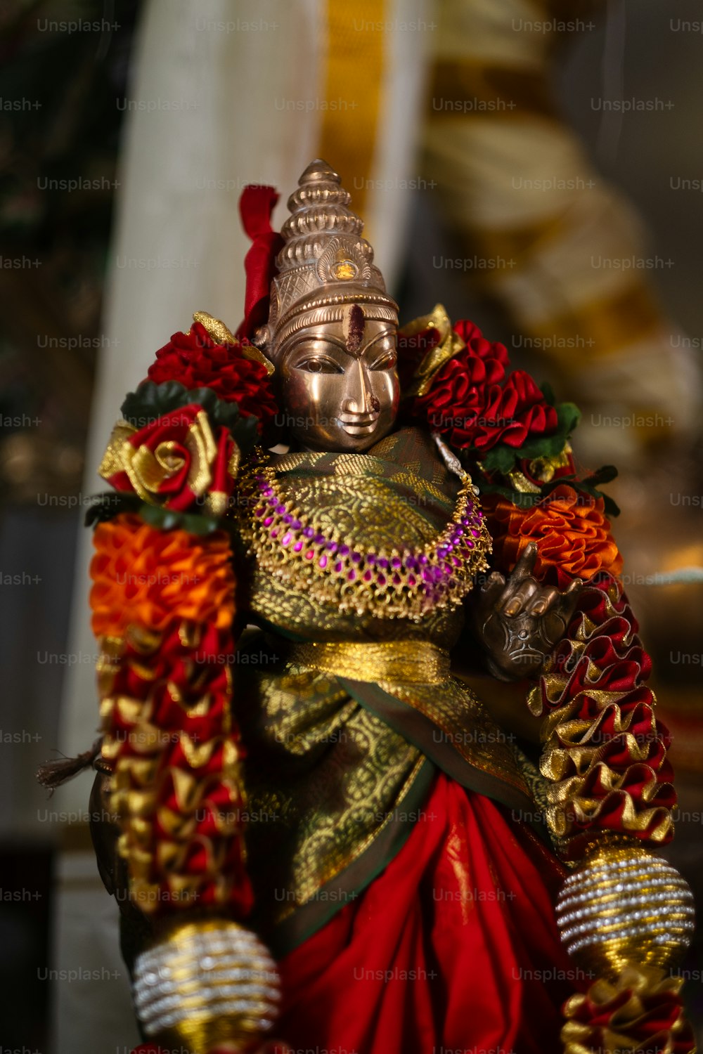 eine Statue einer Person in einem rot-goldenen Outfit