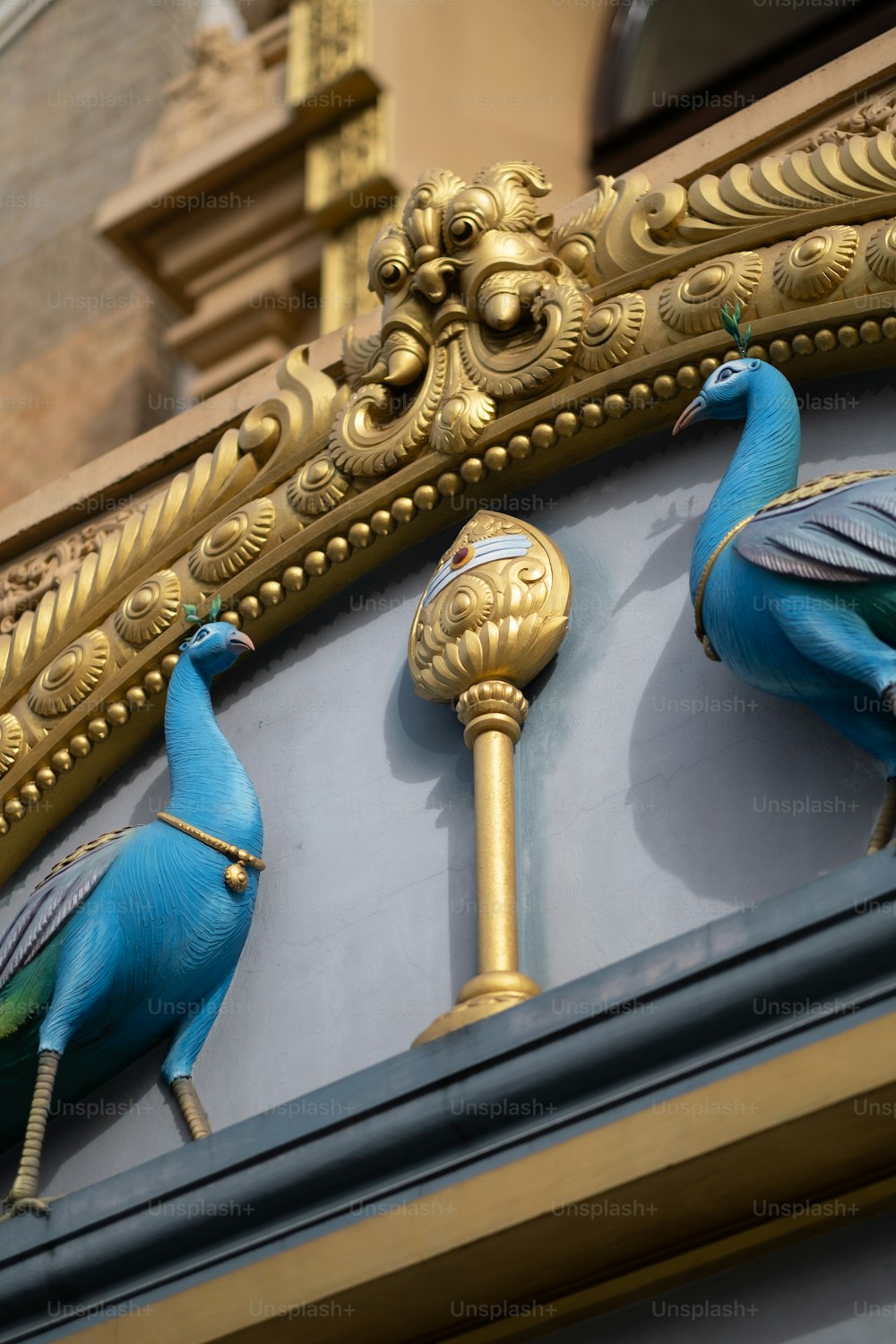 a close up of a clock with two blue birds on it