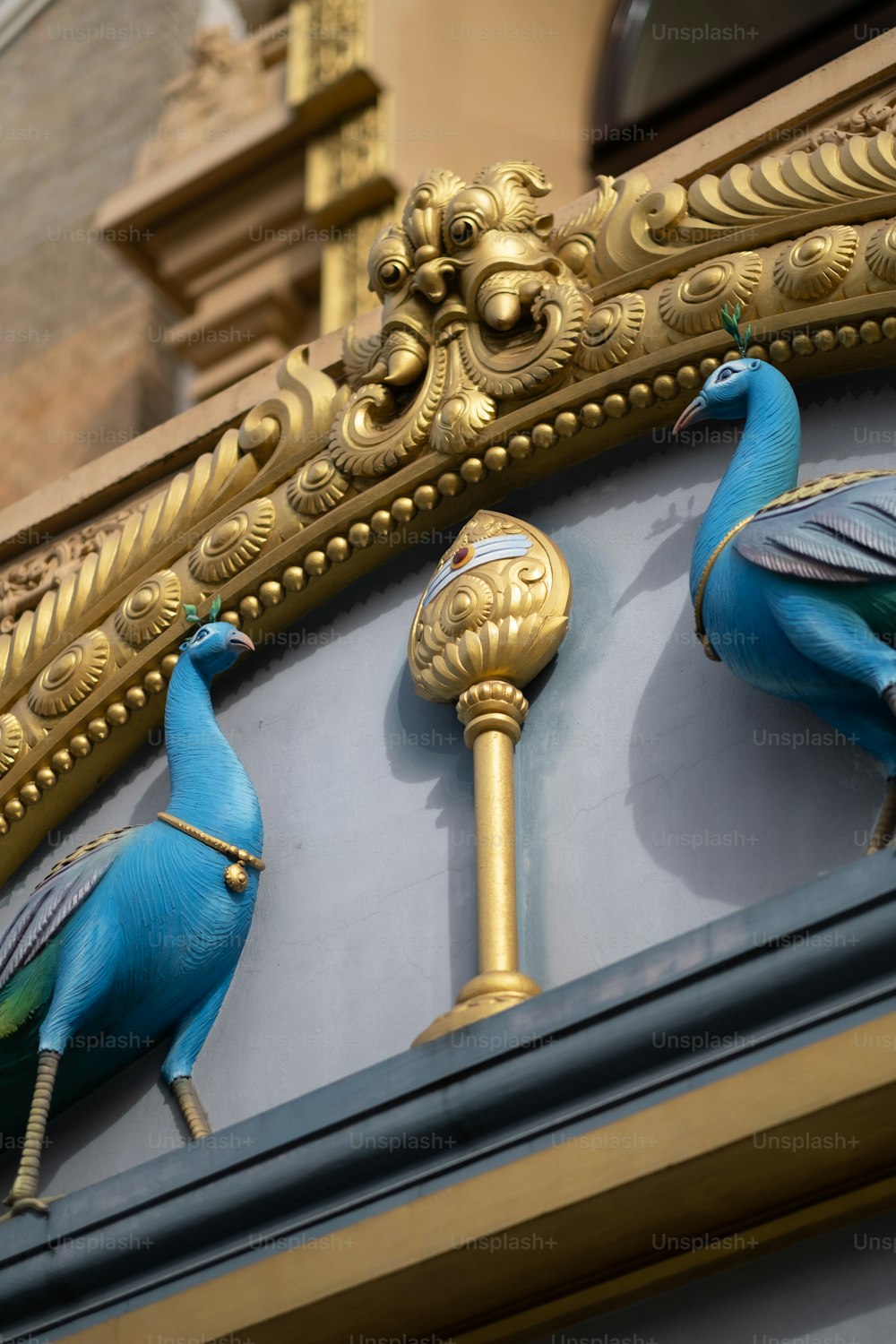 un gros plan d’une horloge avec deux oiseaux bleus dessus