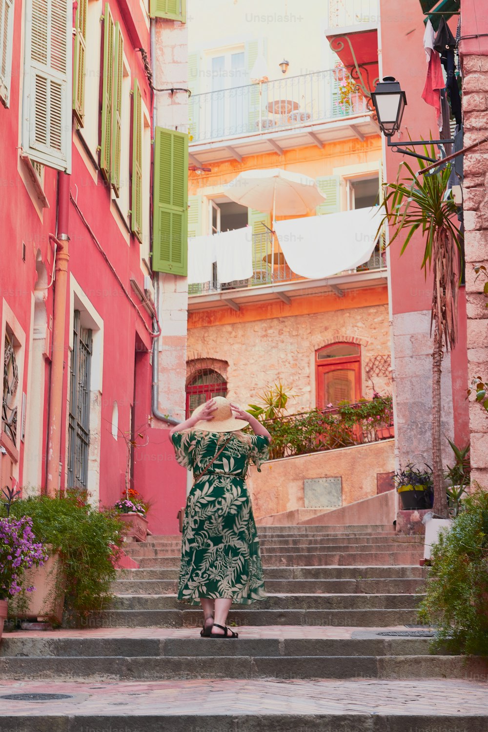 a woman in a green dress walking down some steps