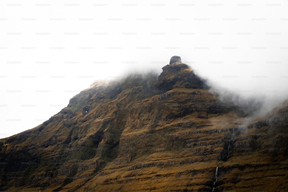 a very tall mountain covered in fog and clouds