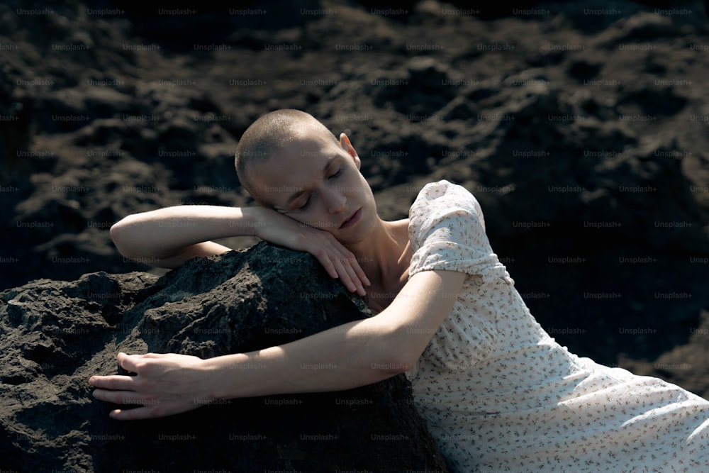 Une femme allongée sur un gros rocher