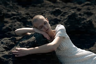 a woman laying on top of a large rock