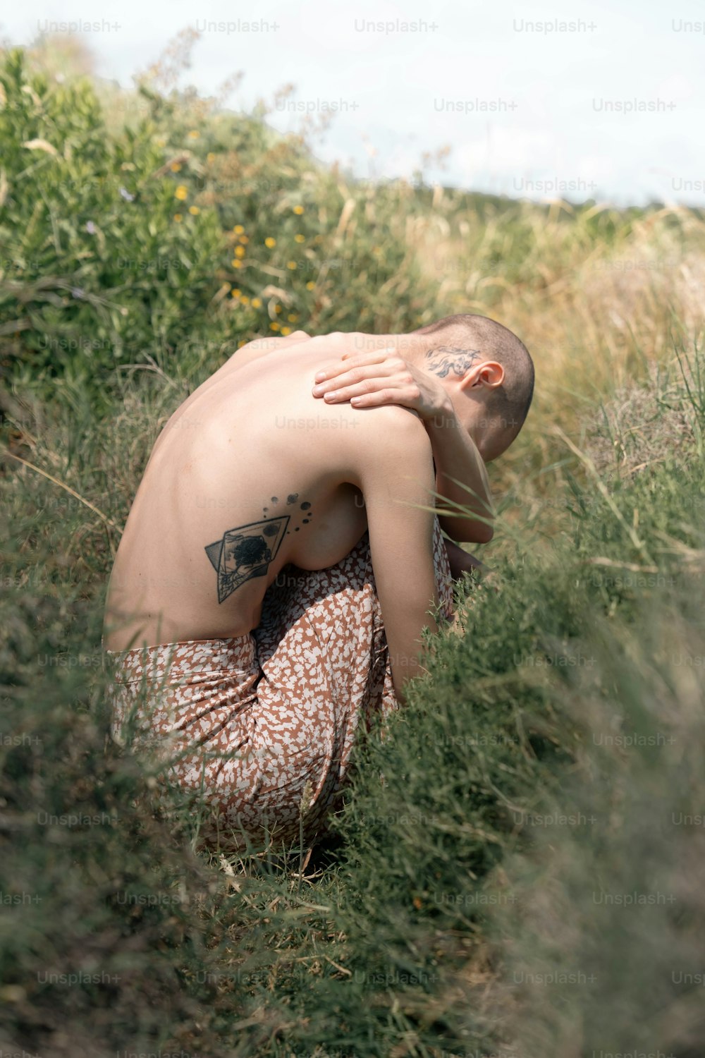 Un uomo a torso nudo in un campo di erba alta