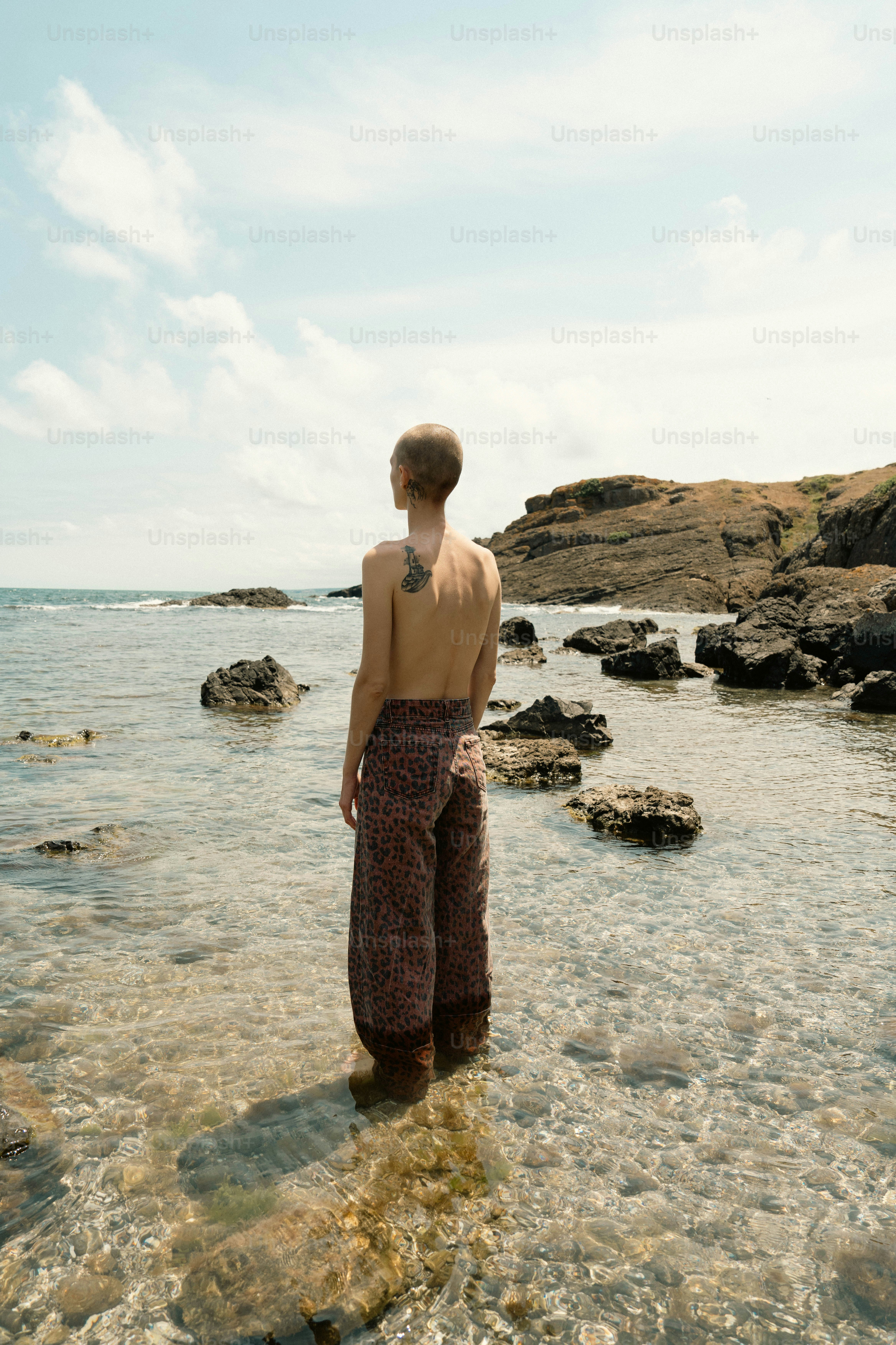 a man standing in the water with his back to the camera