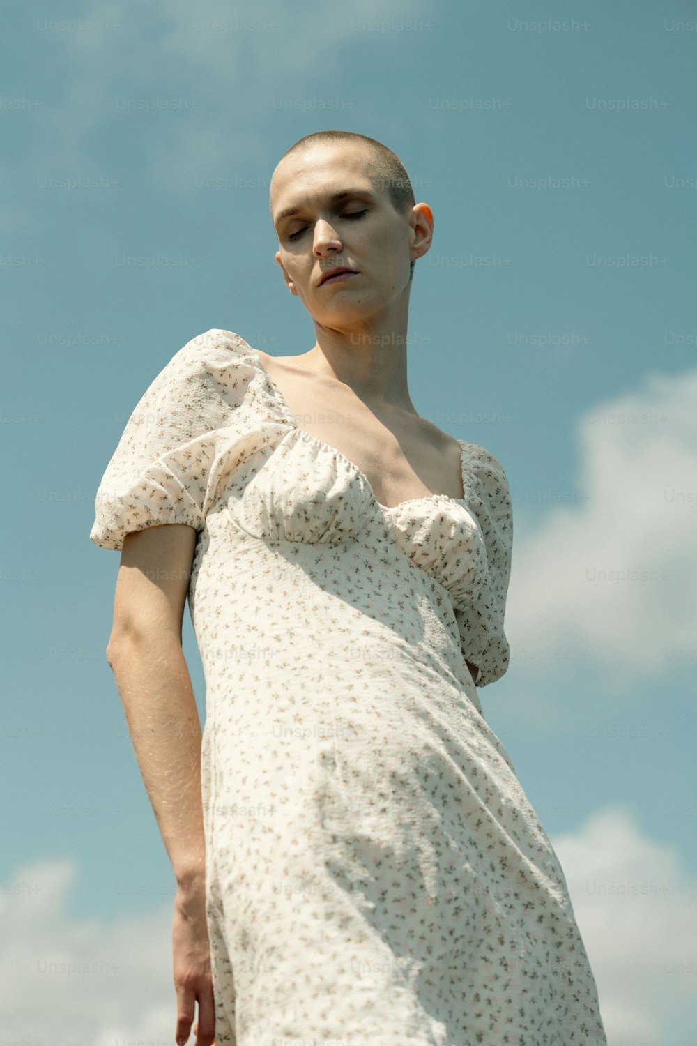 a woman in a white dress with a bald head