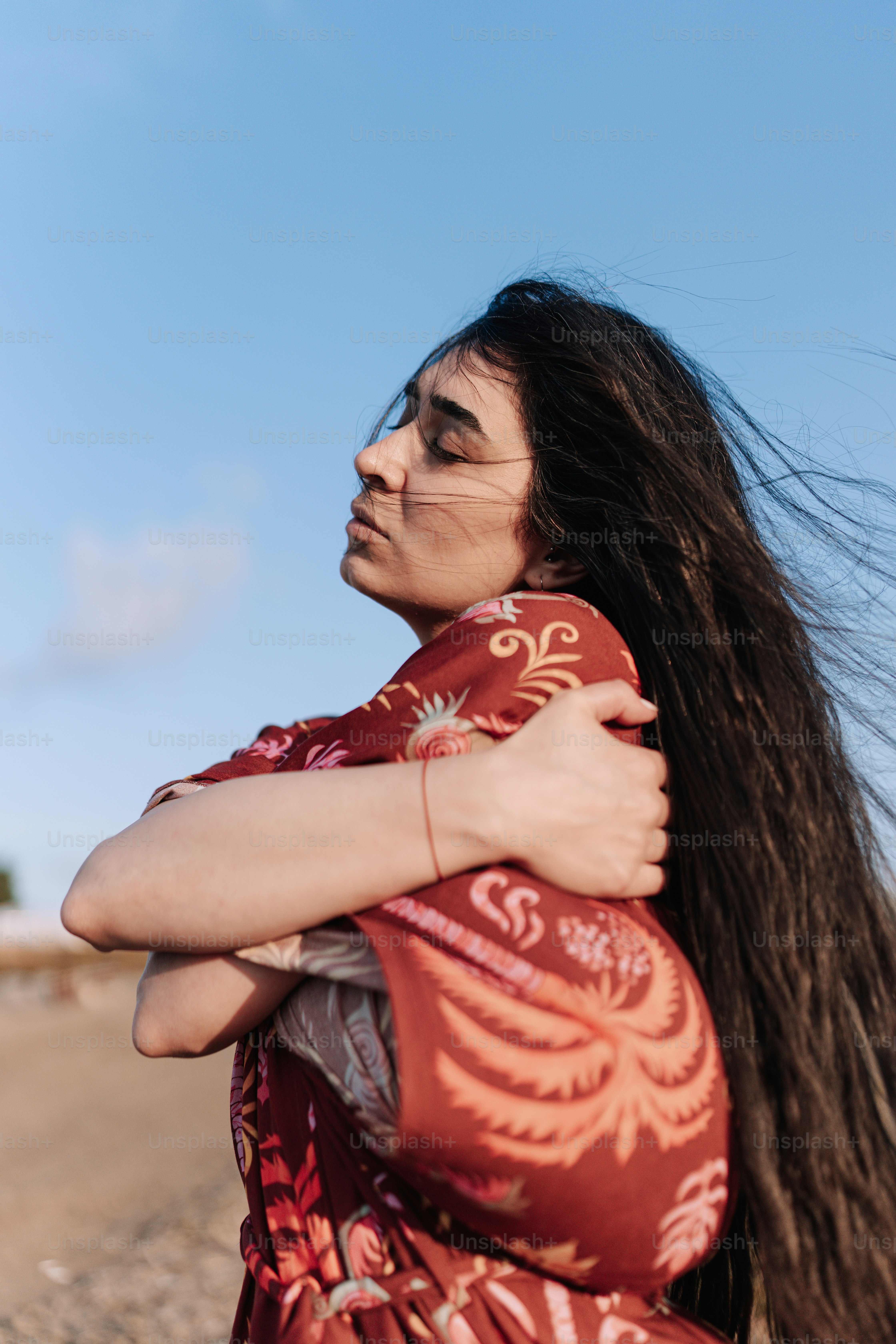 Una donna con i capelli lunghi in piedi su una spiaggia