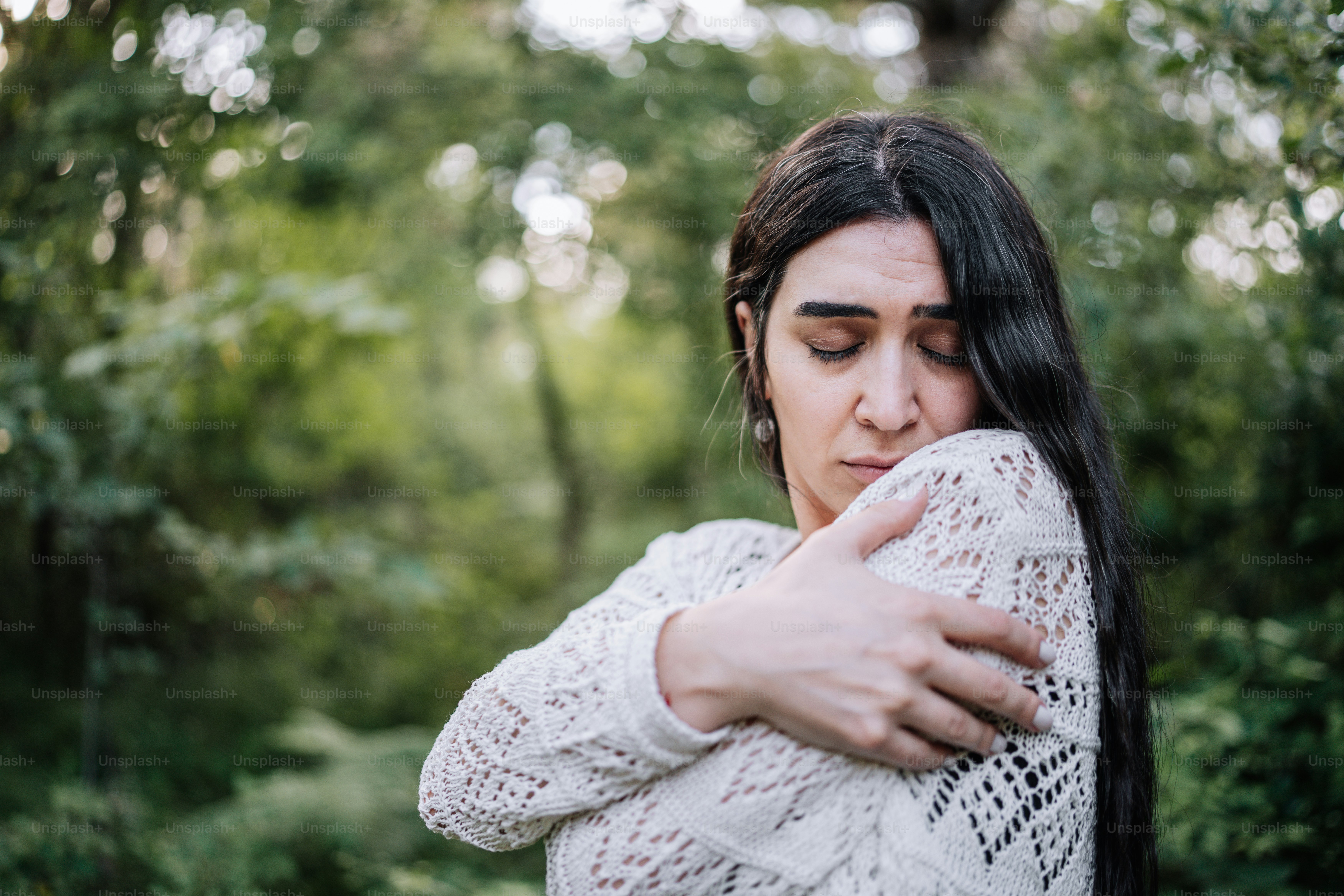 Una donna con lunghi capelli neri che abbraccia un'altra donna